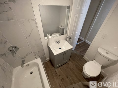A bathroom with a sink, toilet, and mirror.