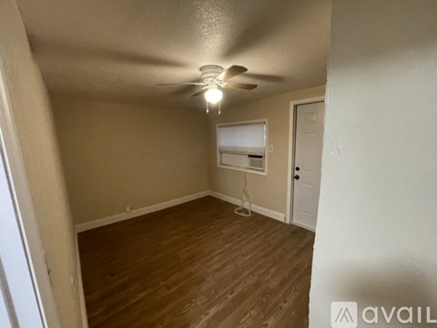 A room with a ceiling fan and wooden flooring.