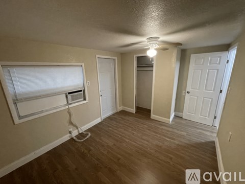 A room with a ceiling fan and wooden flooring.
