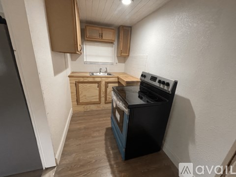A small kitchen with a black stove top oven.