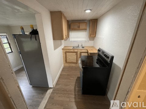 A kitchen with a refrigerator, sink, and stove.