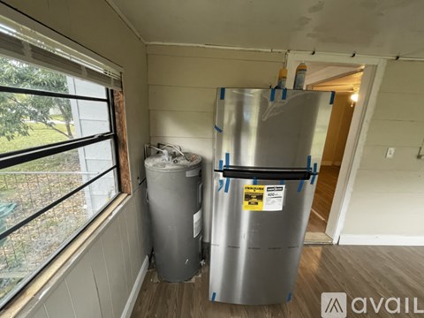 A kitchen with a fridge and a trash can.