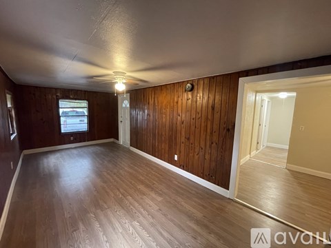 A room with wooden walls and floor and a window.