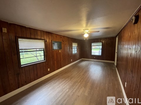 A room with wooden walls and a ceiling fan.
