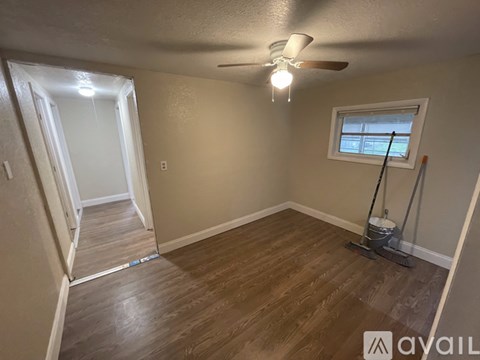 A room with a window and a fan on the ceiling.