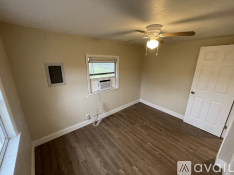A room with a ceiling fan and a window.