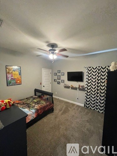 A bedroom with a bed, dresser, and ceiling fan.