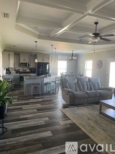 A living room with a grey couch and a wooden floor.