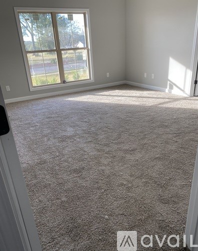 A room with a carpeted floor and a large window.