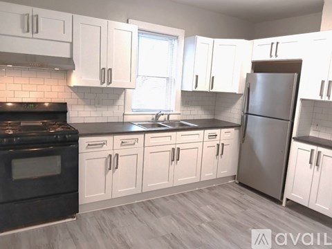 A kitchen with white cabinets and a black stove top oven.