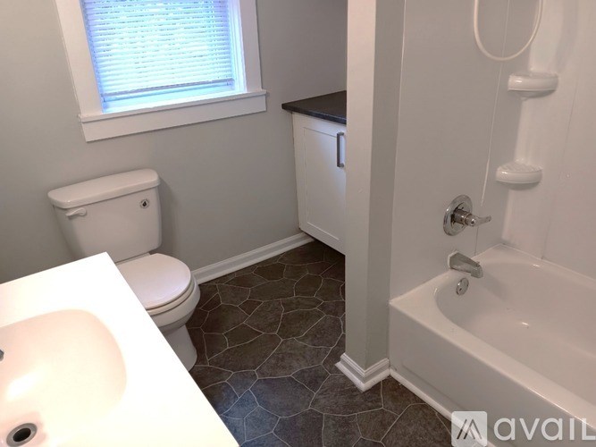 A bathroom with a toilet, sink, and bathtub.