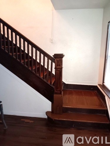 A wooden staircase with a dark wood finish and a light colored wall.