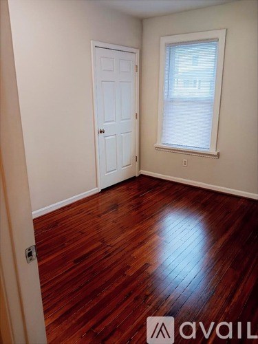 A room with a wooden floor and a white door.