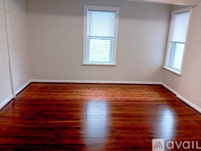 A room with wooden floors and two windows.