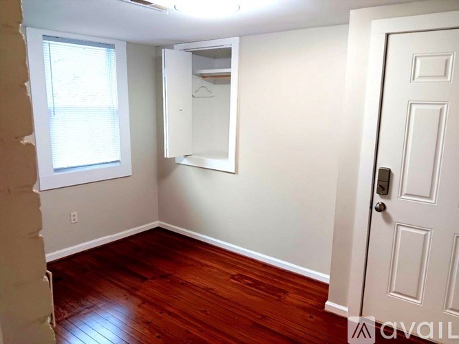 A room with a white door and a window with blinds.