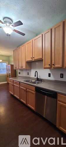 A kitchen with wooden cabinets and a ceiling fan.