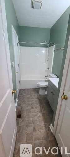 A bathroom with a toilet, sink, and bathtub.