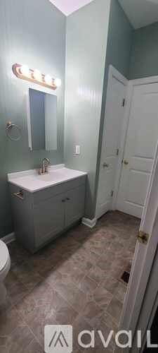 A bathroom with a white sink and a white cabinet.