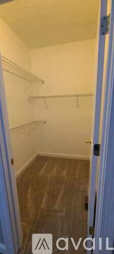 A room with a door and a wall with shelves.