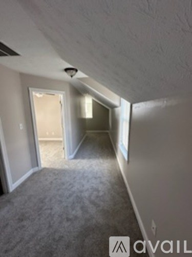 A long hallway with a carpeted floor and white walls.