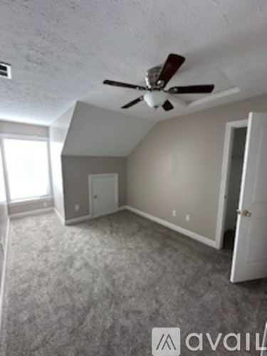 A room with a ceiling fan and a carpeted floor.