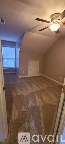 A room with a ceiling fan and a carpeted floor.