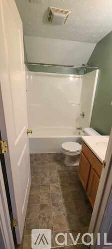 A bathroom with a toilet, sink, and bathtub.