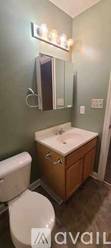 A bathroom with a toilet, sink, and mirror.