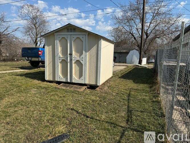 A shed sits in a grassy yard.