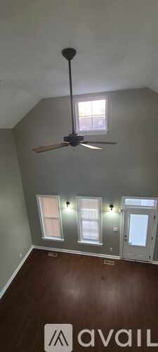 A room with a ceiling fan and a window.
