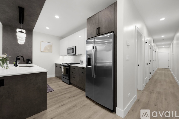 A modern kitchen with dark wood cabinets and a stainless steel refrigerator.