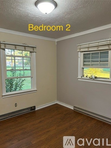 Bedroom 2 has a window with a view of a green lawn.