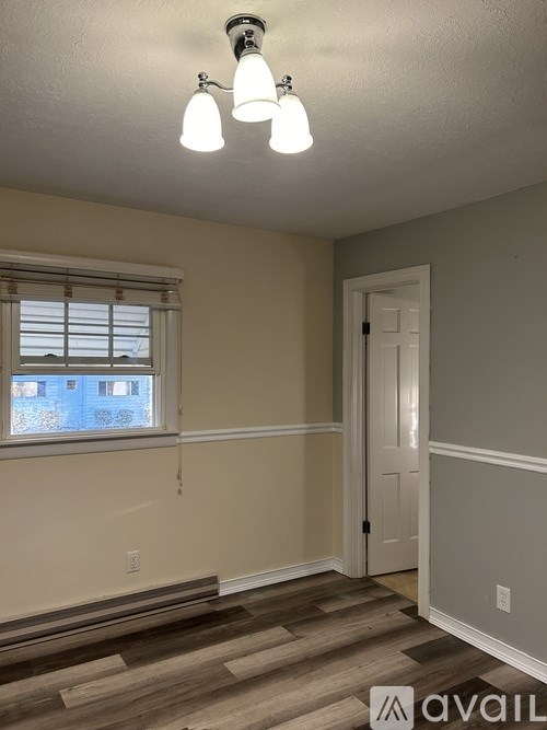 A room with a window and a door is available for rent.