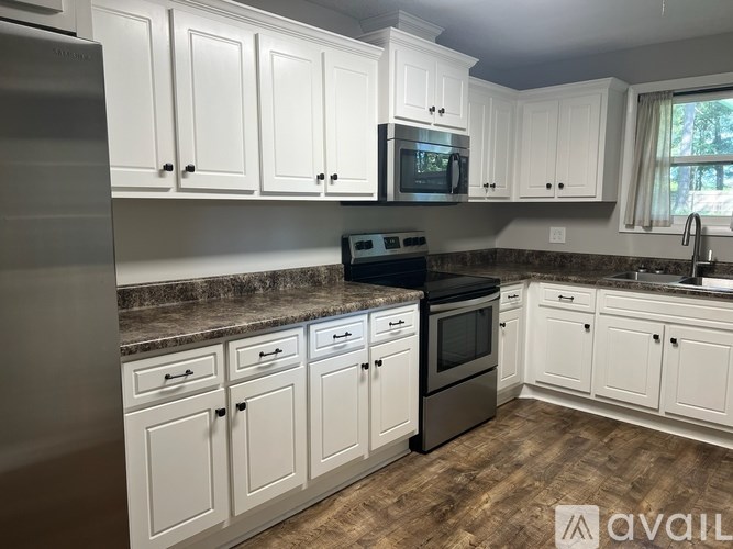 A kitchen with white cabinets and a granite countertop.
