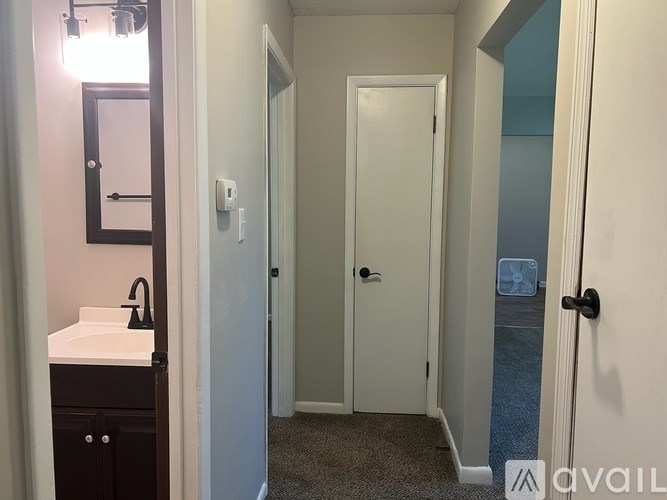 A bathroom with a sink, mirror, and two doors.