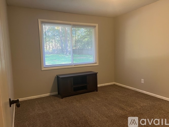 A room with a window and a bench under it.