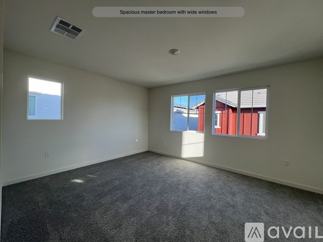 A spacious master bedroom with wide windows.