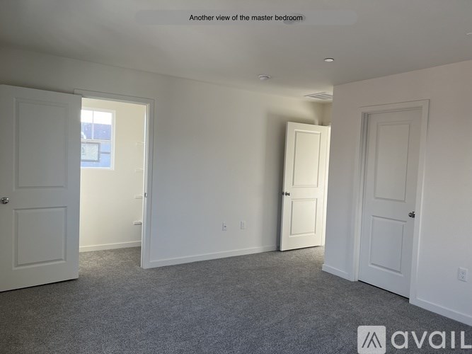 A room with white doors and carpeted floor.