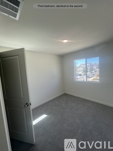 A room with a door and a window showing a city view.