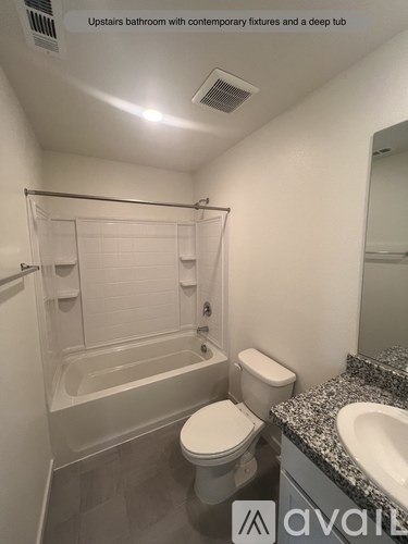 A bathroom with a tub, toilet and sink.