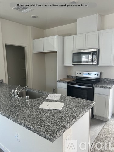 A kitchen with granite countertops and stainless steel appliances.