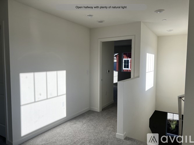 A room with a carpet floor and a door leading to another room.