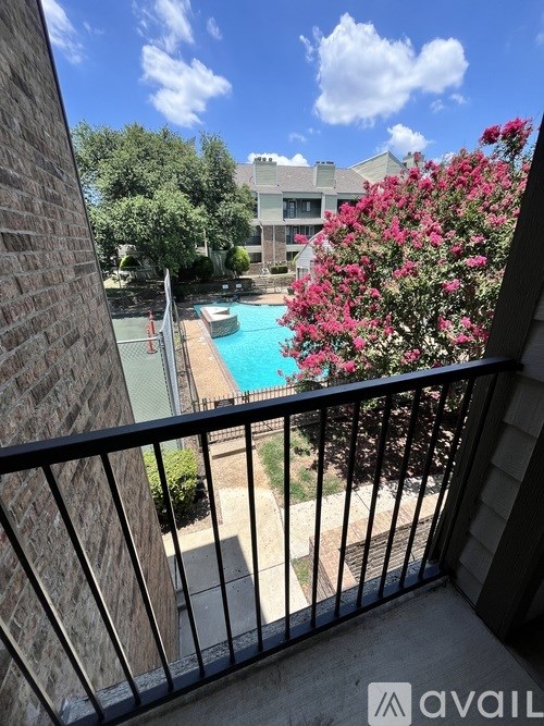 A balcony overlooks a pool and a building.