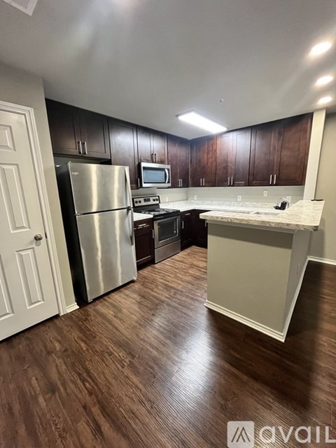 A kitchen with dark wood cabinets and a white fridge.