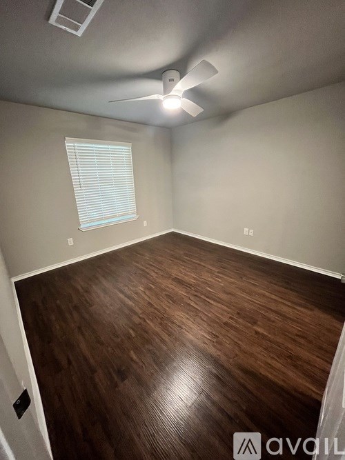 A room with wooden flooring and a ceiling fan.