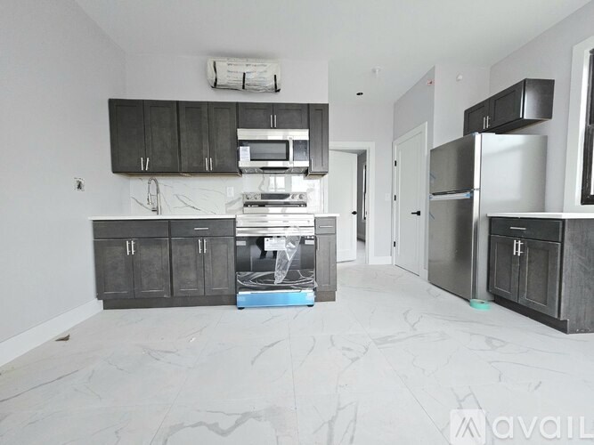 A kitchen with black cabinets and a white floor.