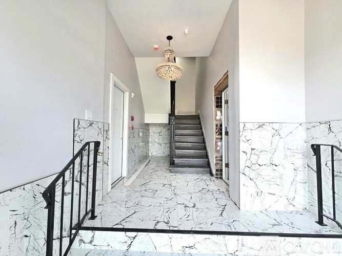A hallway with marble floors and a staircase.