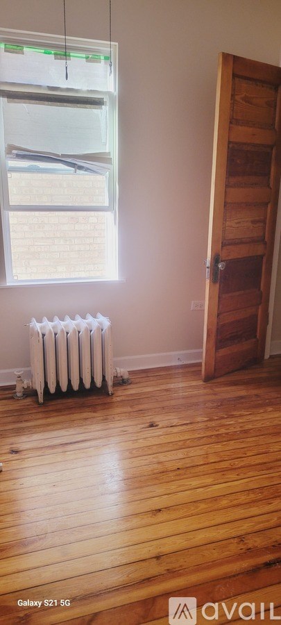 A room with a window and a radiator on the floor.