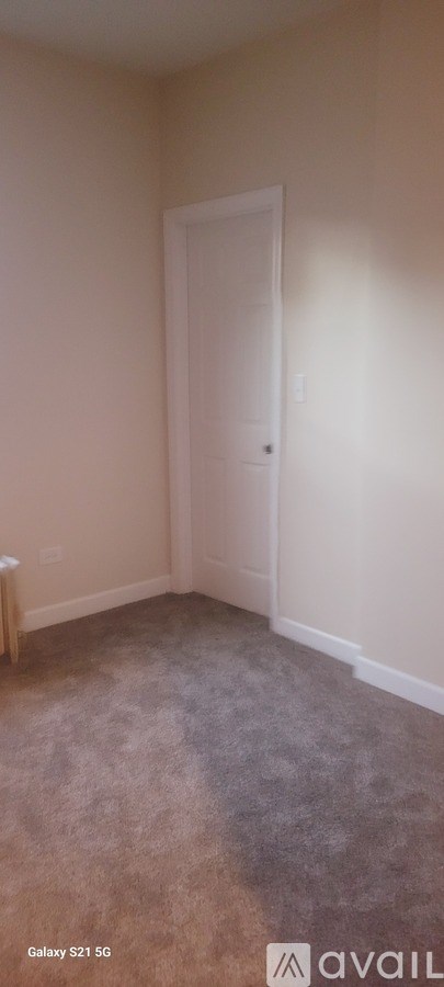 A room with a carpeted floor and a white door.