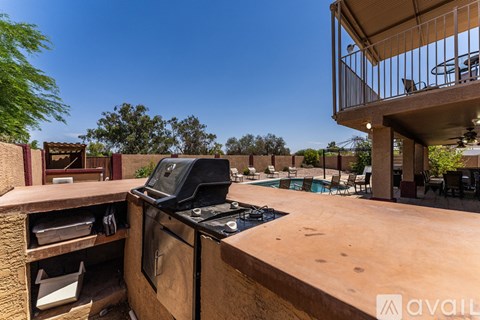 A balcony with a table and chairs overlooks a pool.